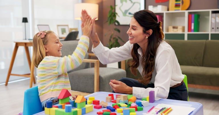 Psicólogo celebrando progreso con un niño
